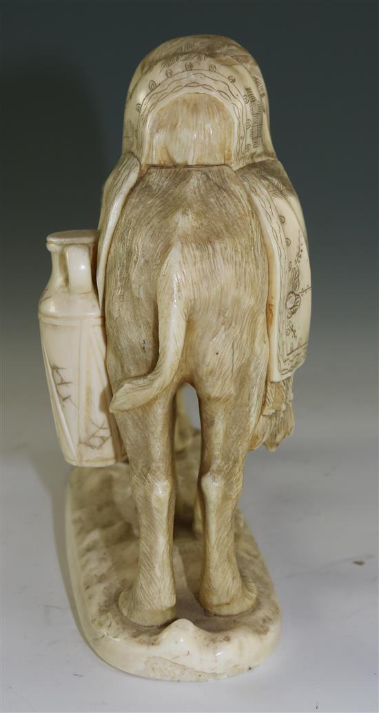 A Japanese sectional walrus ivory okimono of a Bactrian camel and a man, early 20th century, length 26cm